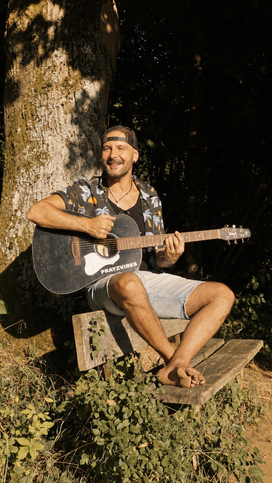 PRAYZVIBES joue de la guitare acoustique en plein air
